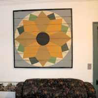 Above the sitting couch is a sunflower made in the style of barn hexes.